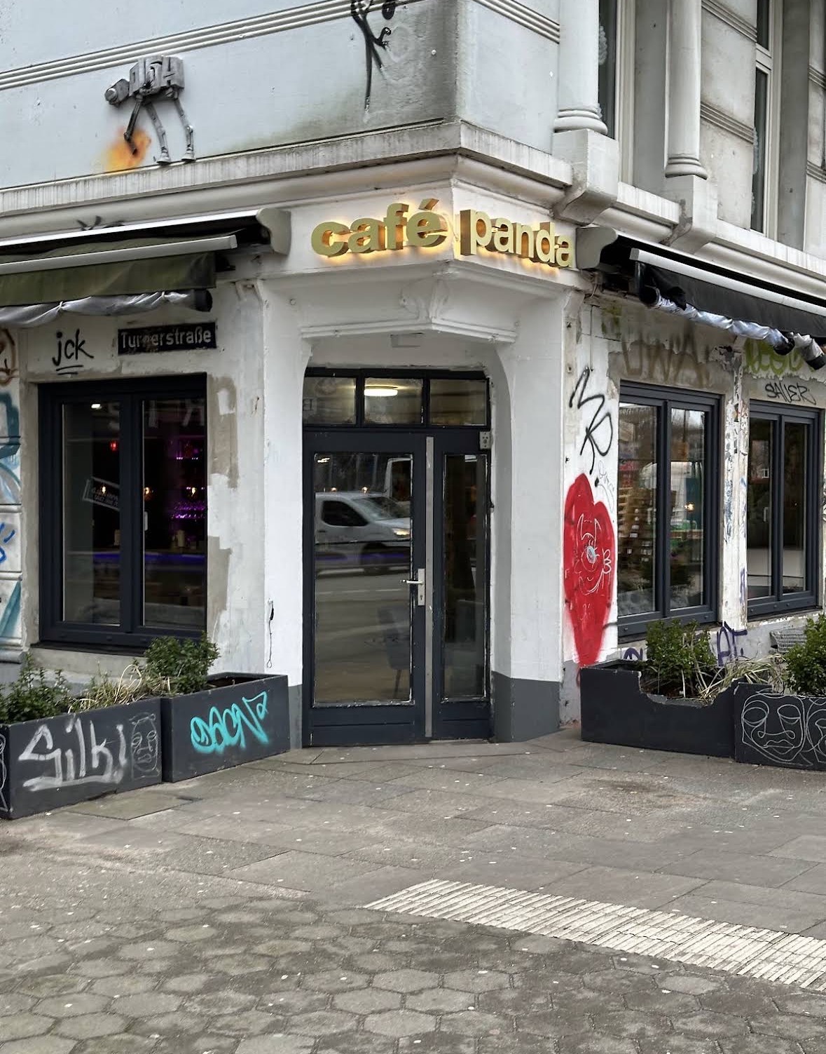 Café Panda Eingang mit goldenem Schild